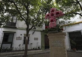 Una cruz de flores es colocada en la Plaza de Santa Marta de Sevilla tras el ataque vandálico