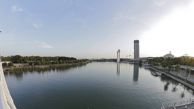 El río Guadalquivir visto desde la Pasarela de la Cartuja con la Torre Sevilla al fondo