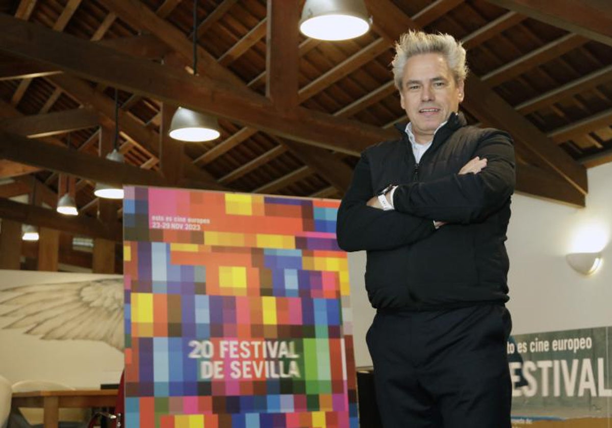 Manuel Cristóbal delante del cartel de la vigésima edición del Festival de Cine de Sevilla, diseñado por Pedro Cabañas