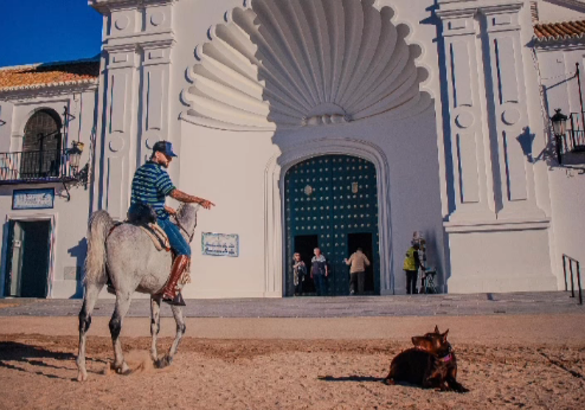 Maluma montando a caballo delante de la ermita de El Rocío junto a su perro