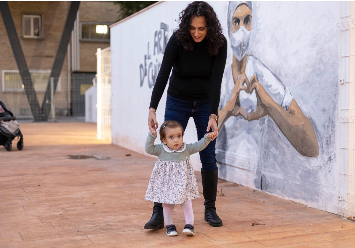 Carmen Listán con su hija Elena, de 16 meses, en la explanada del Hospital Maternal del Virgen del Rocío de Sevilla