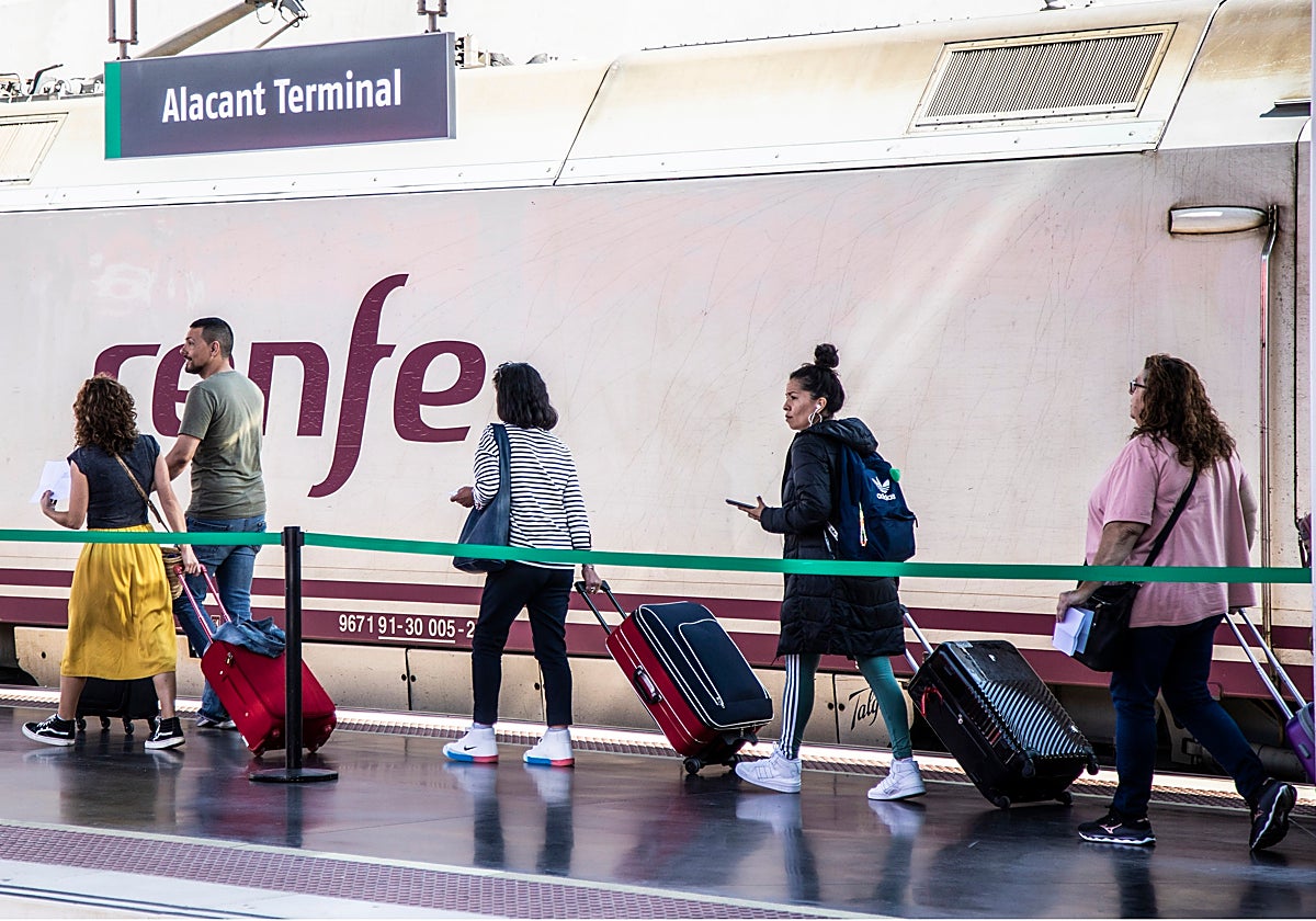 Pasajeros junto a un tren de Renfe, en uno de los andenes de la estación de Alicante