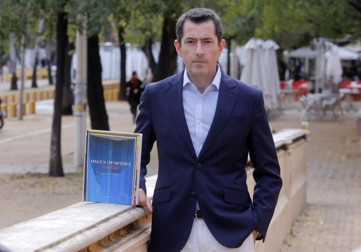 El autor del volumen sobre los 73 pintores andaluces, Juan Alfonso Contreras, junto a su libro