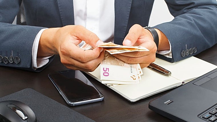 Imagen de archivo de un trabajador contando billetes