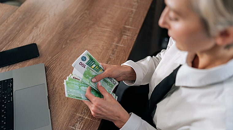 Imagen de archivo de una trabajadora contando el dinero recibido por su nómina