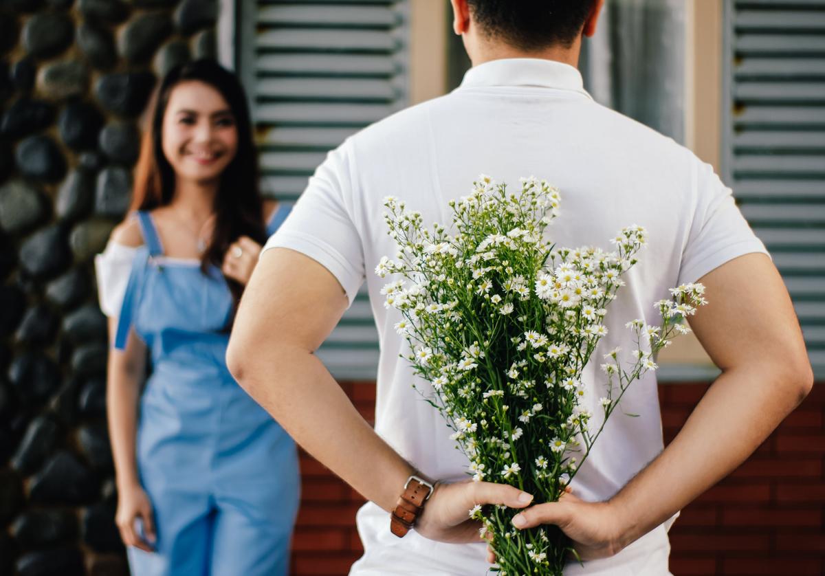 Un joven trata de sorprender a su pareja con un ramo de flores por San Valentín