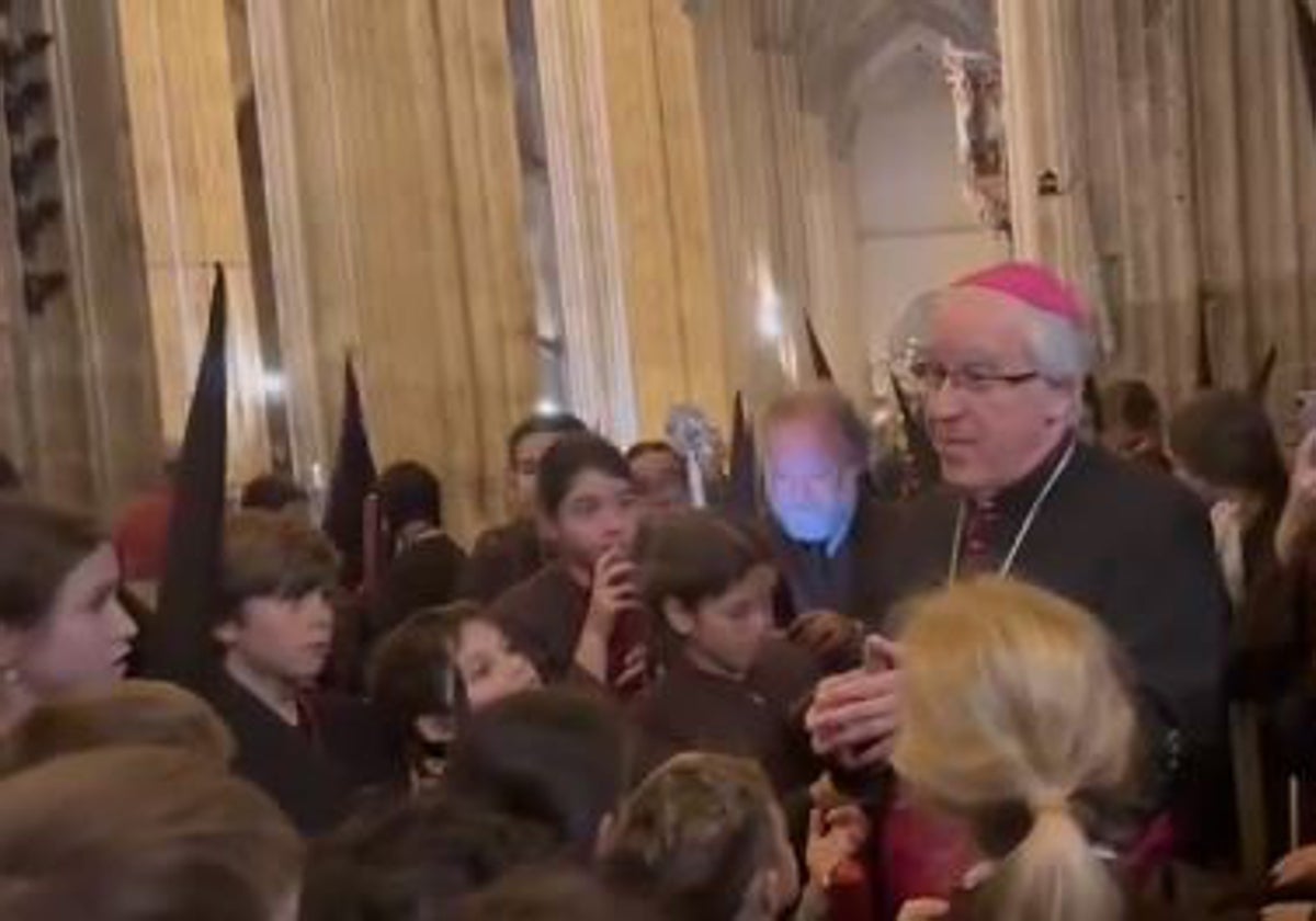 El arzobispo de Sevilla, monseñor José Ángel Saiz Meneses, junto a los nazarenos del Buen Fin