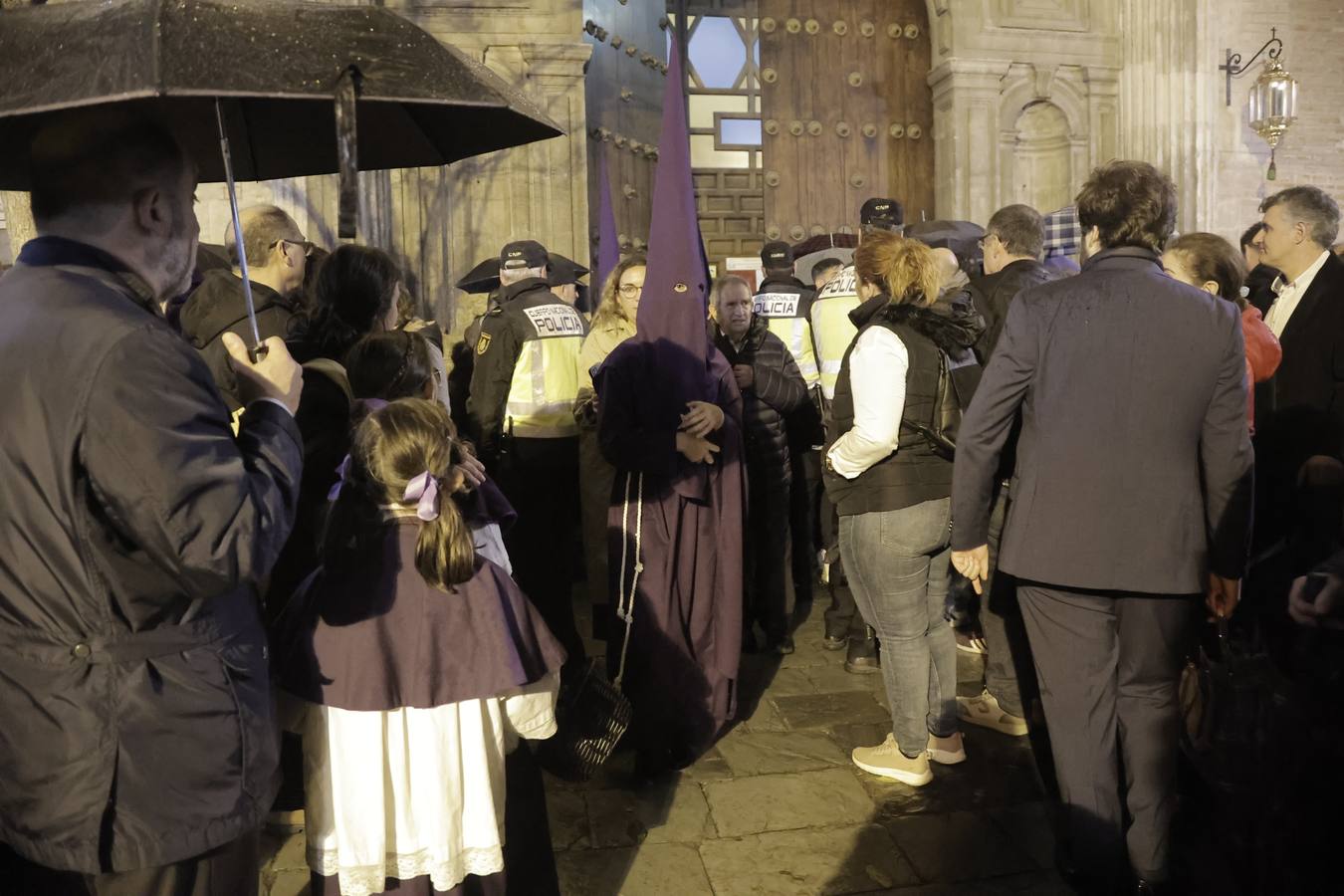 Nazarenos y costaleros se lamentan a las puertas de la iglesia de la Anunciación tras la decisión de no salir de la hermandad del Valle