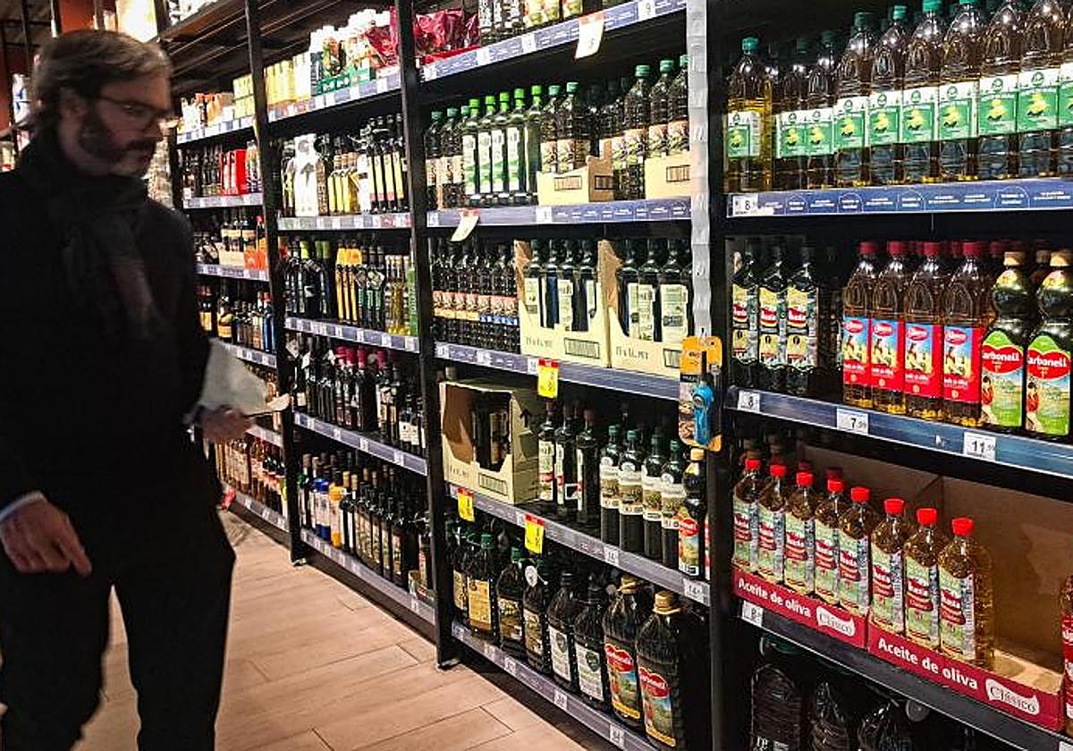 Un hombre compra aceite de oliva en un supermercado