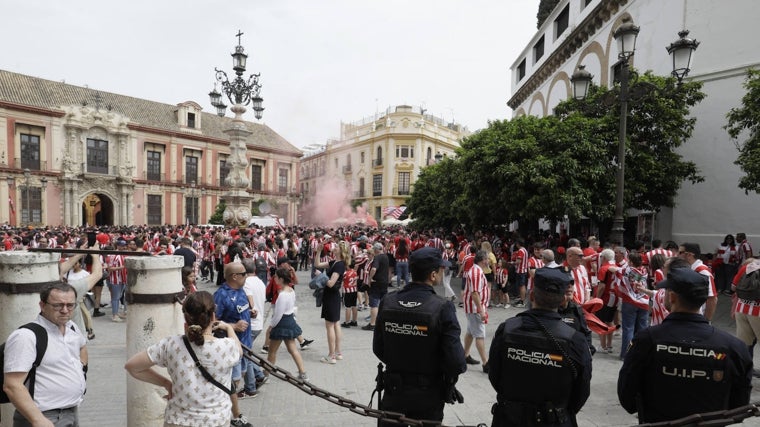 Varios agentes de la Policía Nacional vigilan a miles de aficionados que se concentraron este sábado en la plaza Virgen de los Reyes