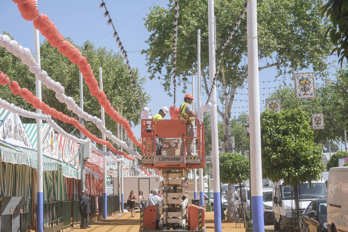 Operarios colocan los farolillos que se estropearon durante la lluvia de esta semana