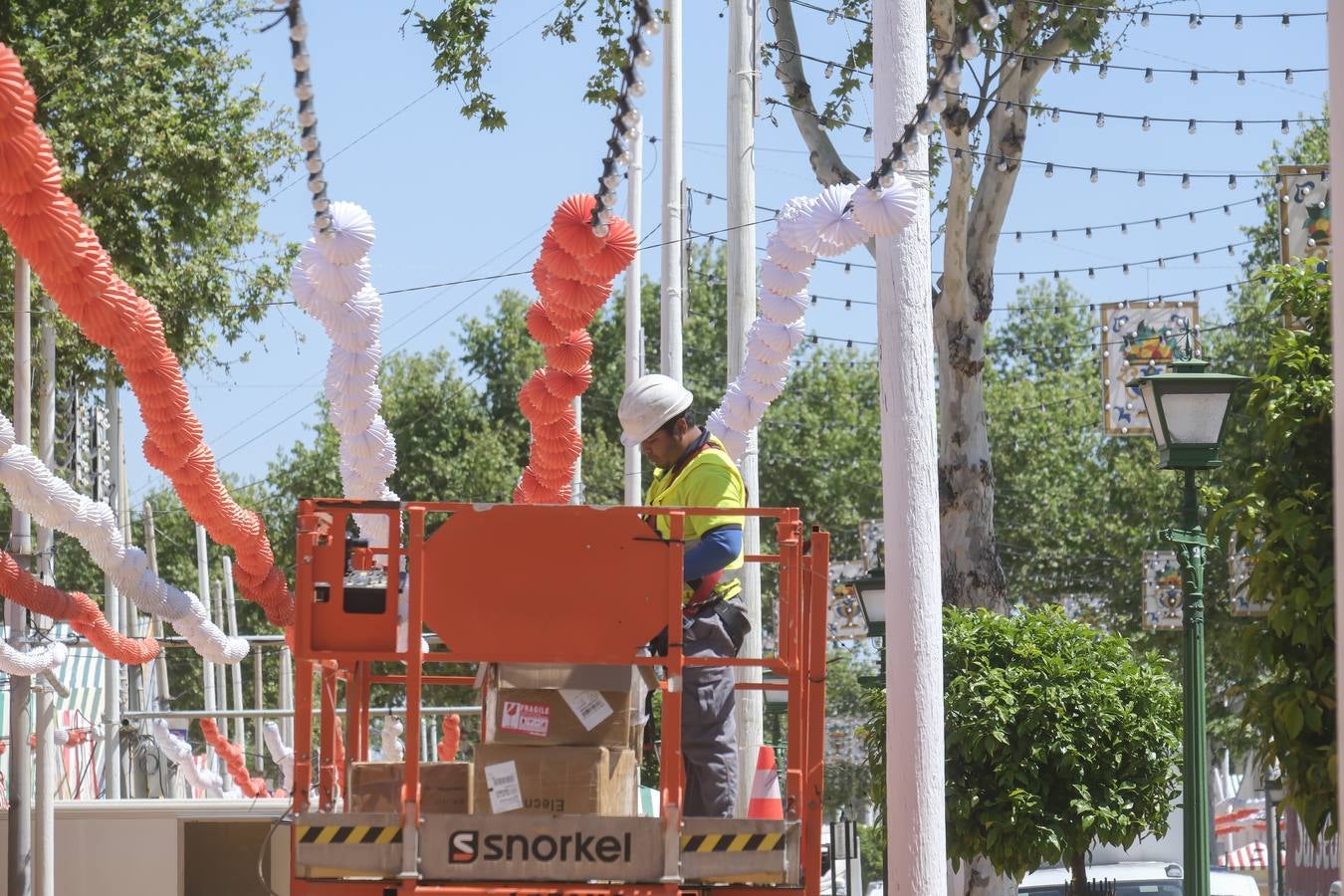 Operarios colocan los farolillos que se estropearon durante la lluvia de esta semana