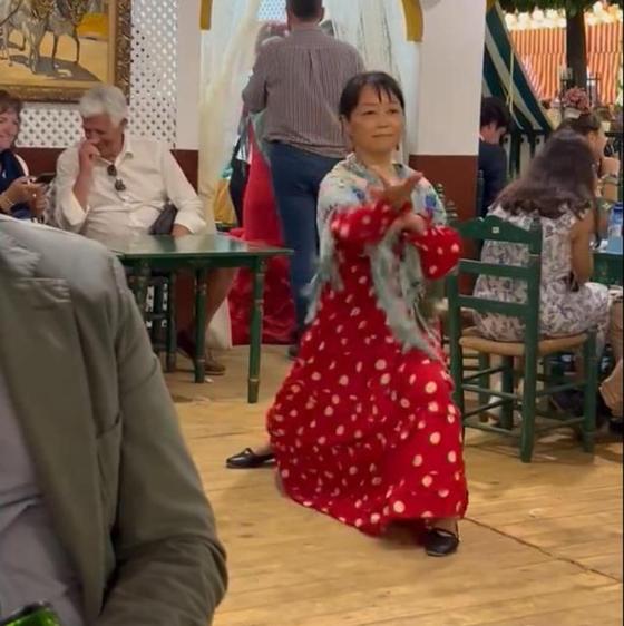 Una mujer de origen asiático practica taichí en una caseta de la Feria de Abril de Sevilla