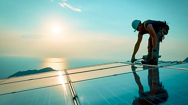 Imagen de una persona instalando placas fotovoltaicas en una vivienda