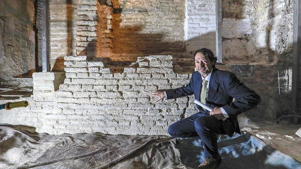 El arqueólogo José Antonio Valiente señala el muro del hejal que ha salido a la luz en la iglesia