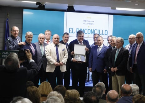 Imagen secundaria 1 - Arriba los hermanos Javier y Carlos de Rueda, actuales dueños de 'El Rinconcillo' , sobre estas líneas la autora del libro, Fátima Rosado de Rueda durante su intervención y los miembros de la tertulia 'El primer viernes de cada mes' hicieron entrega a los propietarios de la taberna de una plaza conmemorativa 