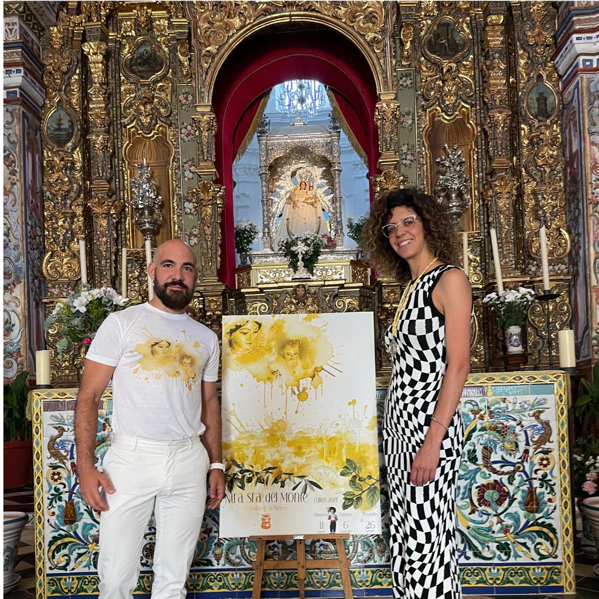 El artista Curro Borrajeros y Pilar Trigo, hermana mayor de la hermandad de la Virgen del Monte, junto a su cartel de romería y cultos