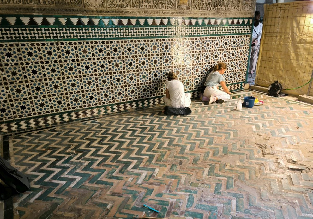 Dos restauradoras trabajan sobre las solerías en una de las estancias del palacio mudéjar el Alcázar