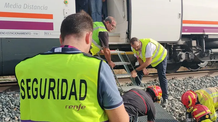 Seguridad del tren y bomberos colocando plataforma para que bajaran viajeros