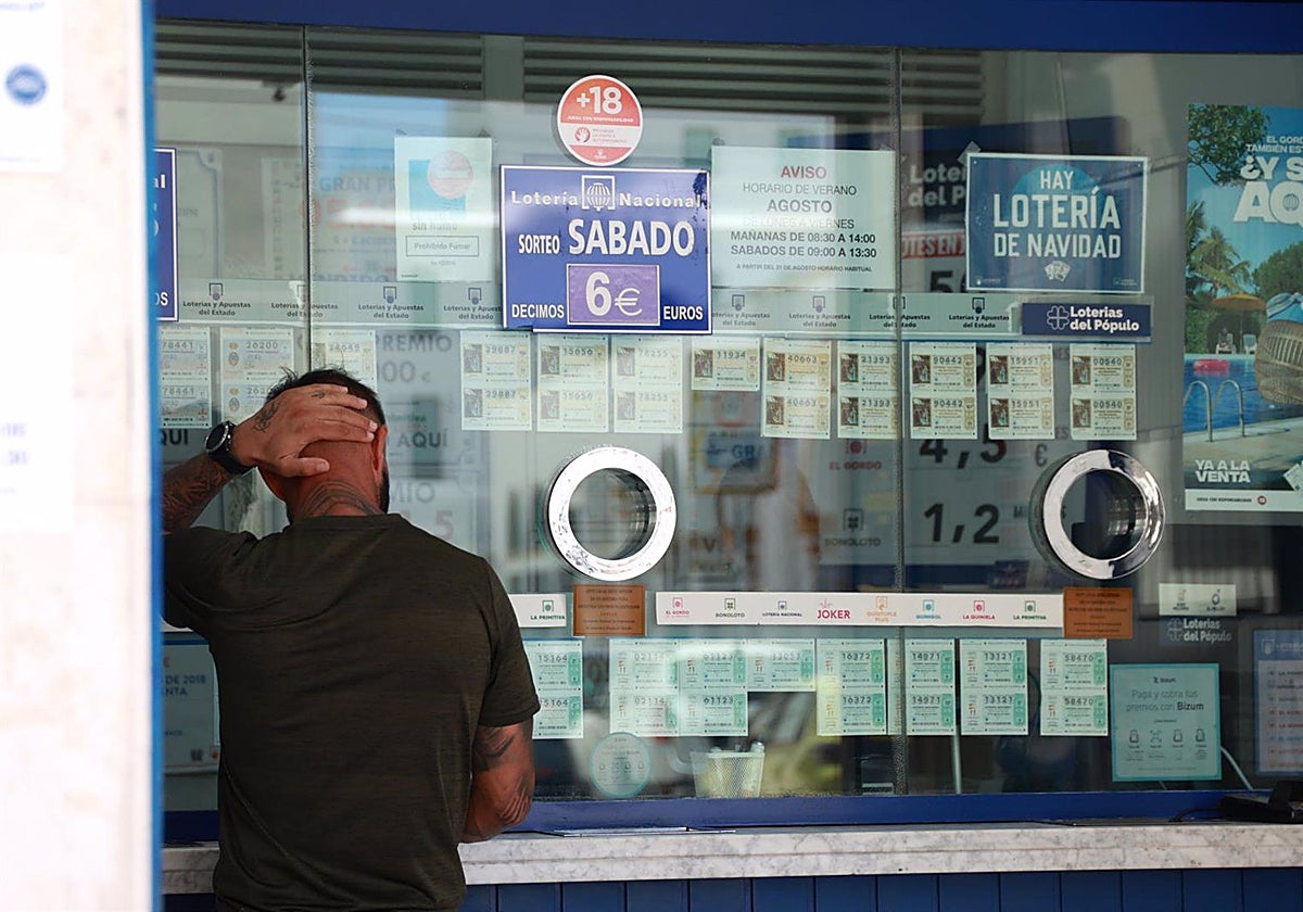 Una persona se dispone a adquirir un boleto en una Administración de Loterias