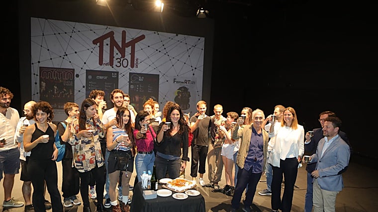 Miembros de las compañías participantes en los festivales de TNT junto a los representantes institucionales, brindan por el treinta aniversario ante la tarta conmemorativa en el escenario