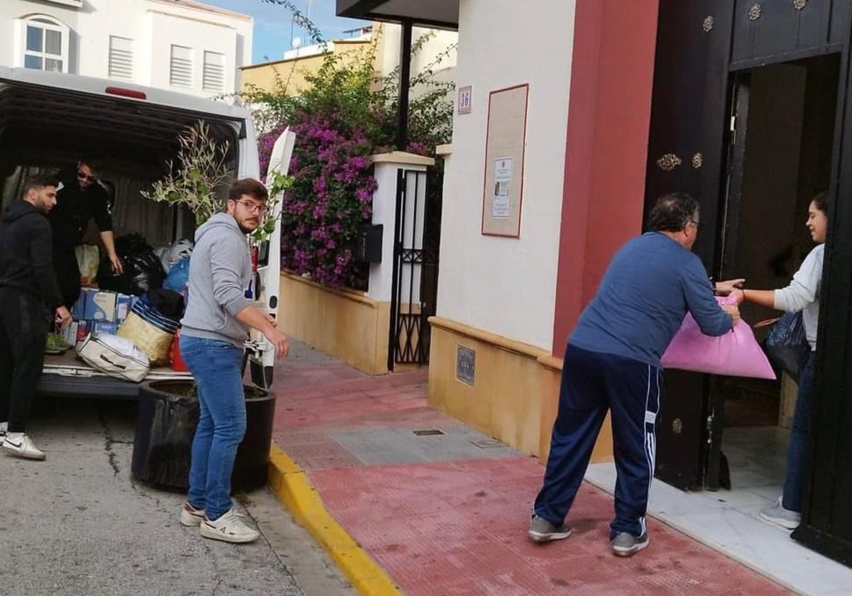 Cadena humana en la hermandad de la Cena  y ONG Nazarena para la Esperanza cargando vehículos