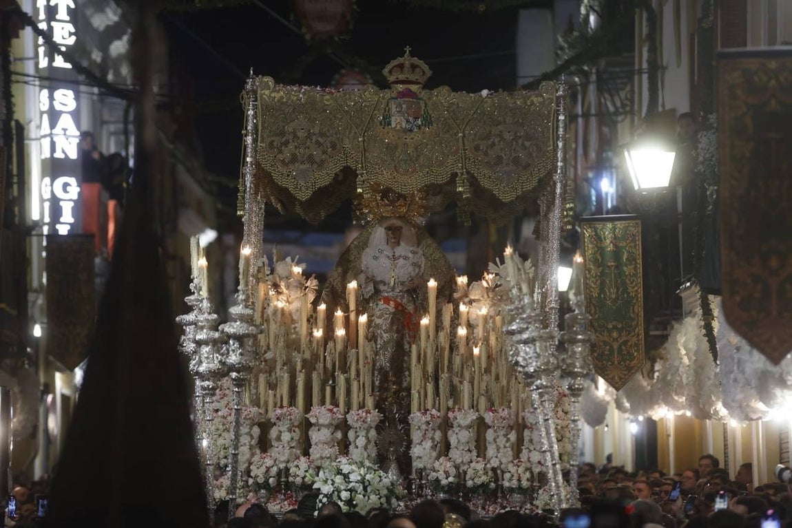 Discurrir de la Macarena por una abarrotada calle Parras ya de madrugada
