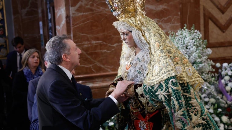 Cristóbal Martínez tocando las manos de la Virgen