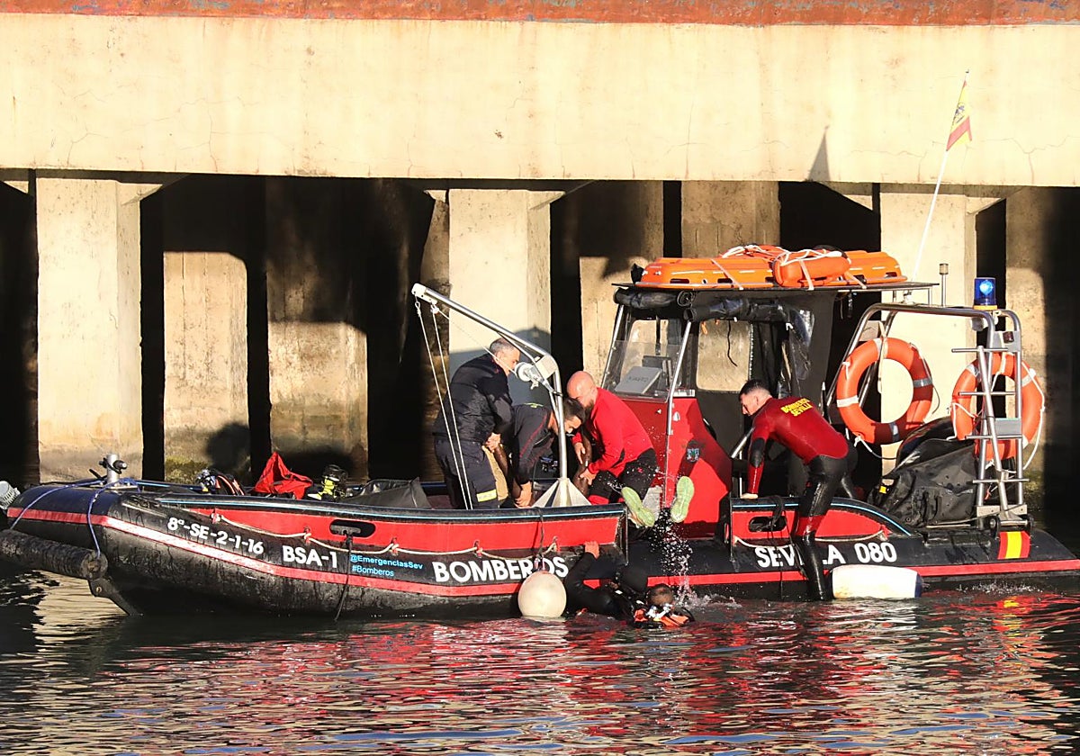 Bomberos rescatando el cadáver del mantero senegalés