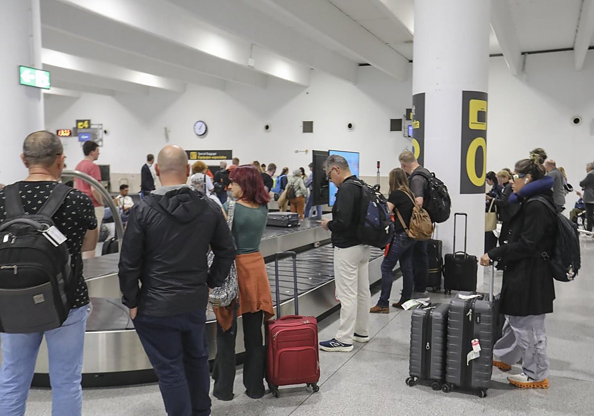 Viajeros esperando sus equipajes en la terminal de llegadas del aeropuerto de Sevilla