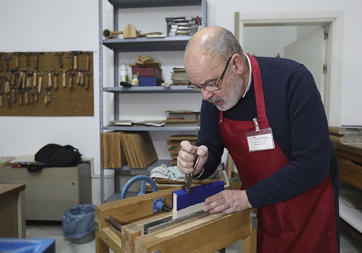 Antonio Moreno trabaja sobre un libro en su taller del Archivo Municipal