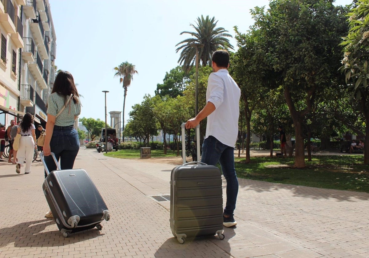 Dos turistas caminan con sus maletas por el centro de Málaga capital