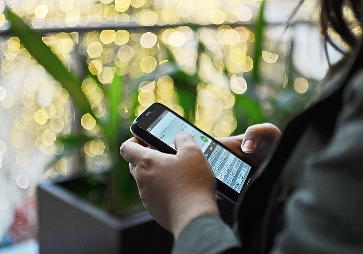 Foto de archivo de una mujer usando la aplicación Whatsapp