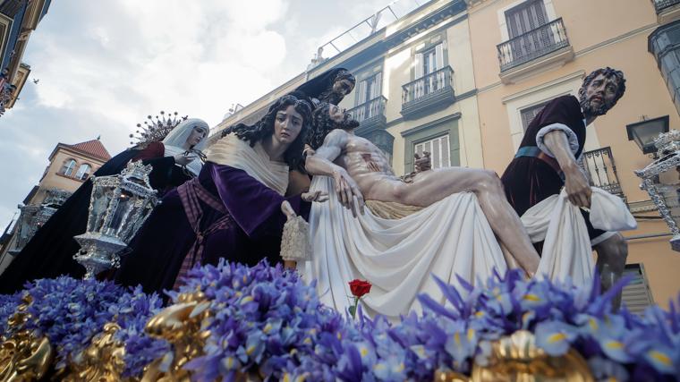 La rosa roja bajo la mano del Cristo de la Caridad simboliza la última gota de sangre de Jesús