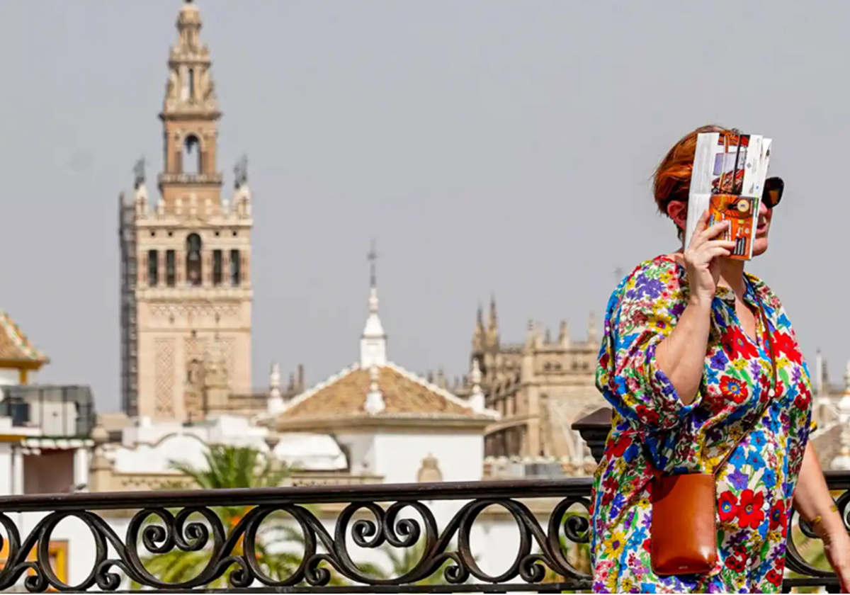 Una mujer pasea por el Puente de Triana en un día soleado en Sevilla