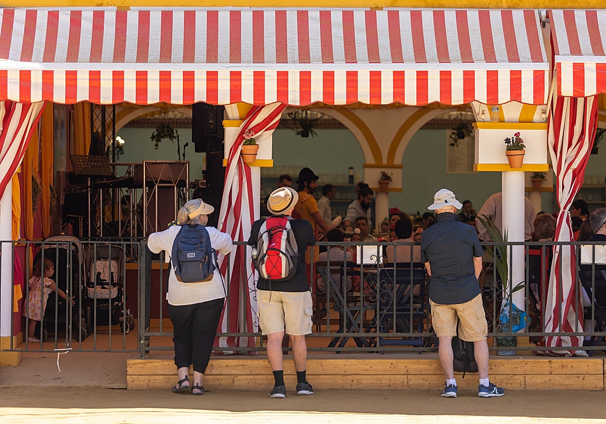 Turistas asomados a una caseta de la Feria de Sevilla