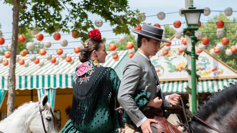 Pareja disfrutando de la Feria de Sevilla en caballo