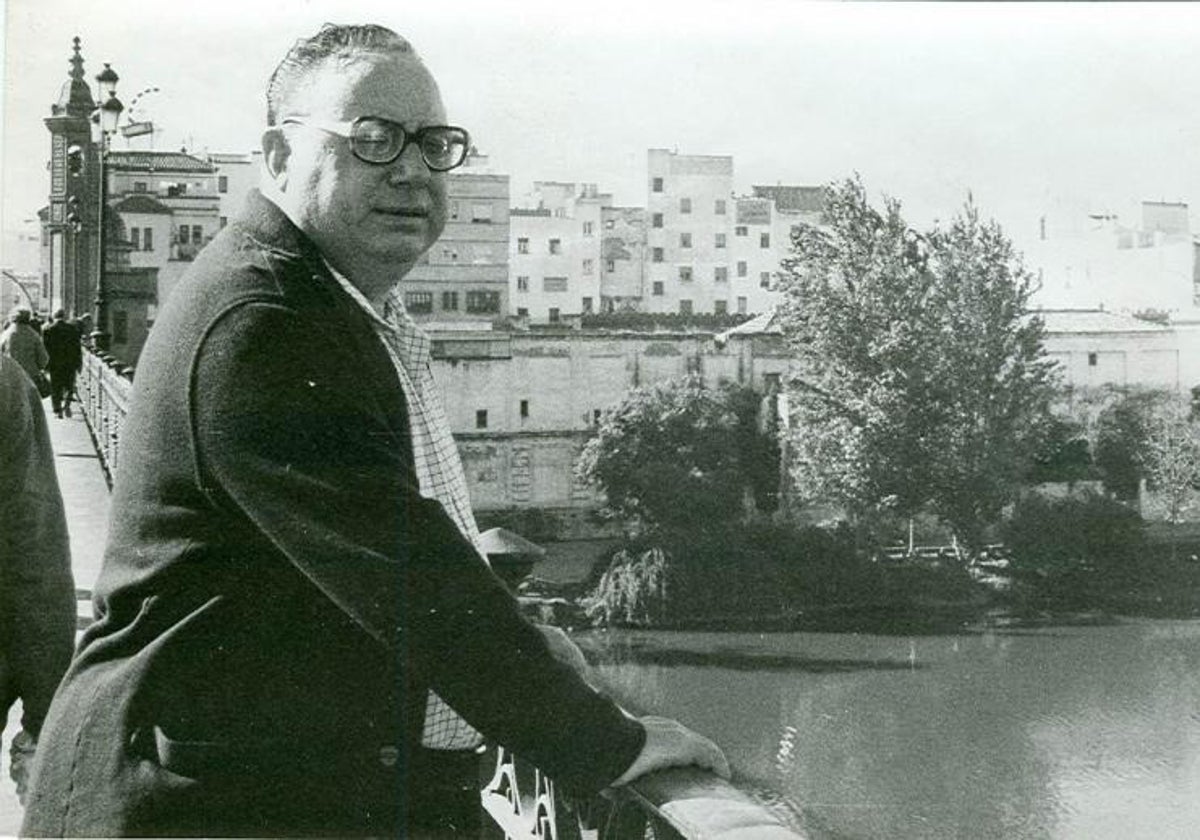 El Pali se apoya en la baranda del puente de Triana con la estampa de la capillita del Carmen y el Paseo de la O al fondo en 1979