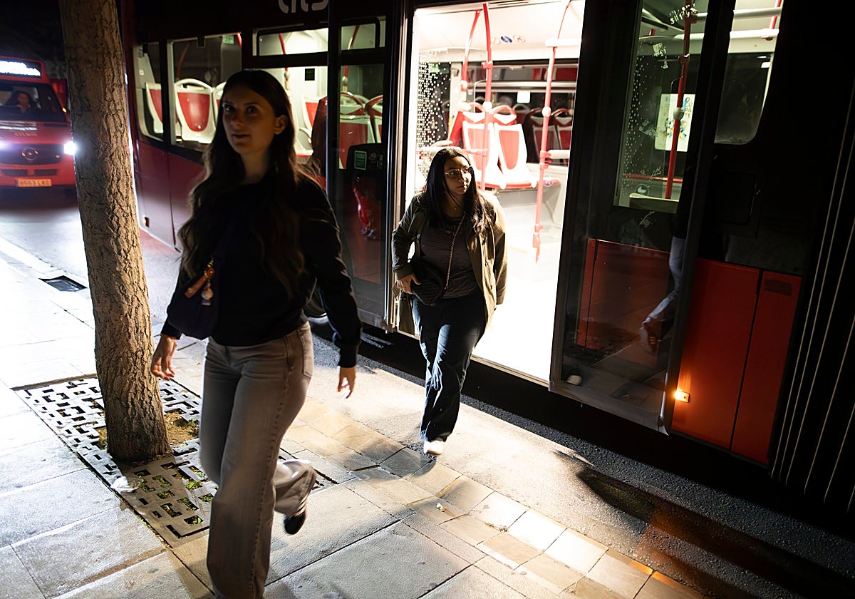 Dos usuarias del autobús bajan en la calle a oscuras el pasado 28 de abril durante el apagón