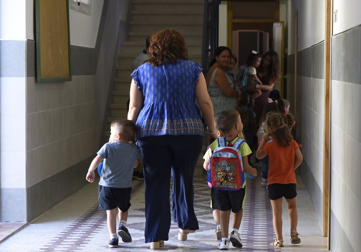 Niños caminan junto a su profesora en el colegio Tierno Galván