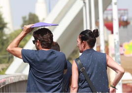 Personas cruzando el Puente de la Barqueta en un día con mucho sol en Sevilla