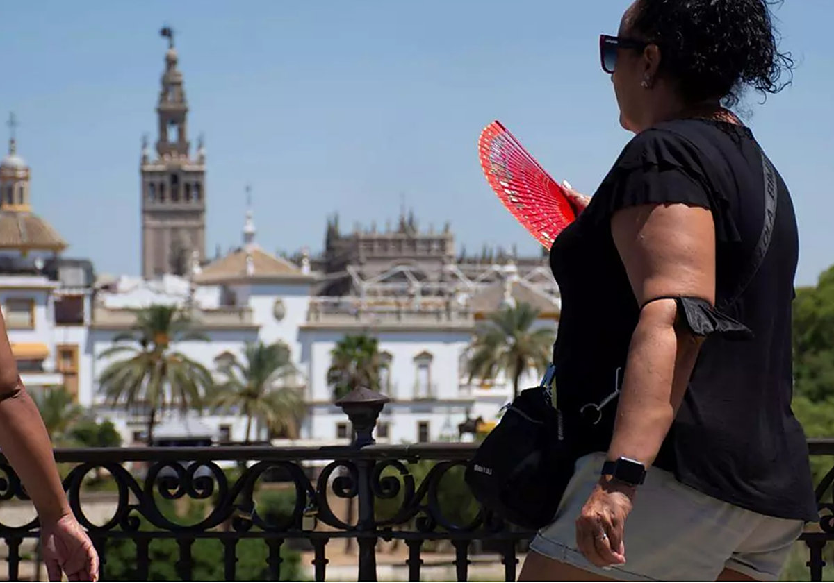 Una mujere camina por el Puente el Triana durante un día de calor en Sevilla