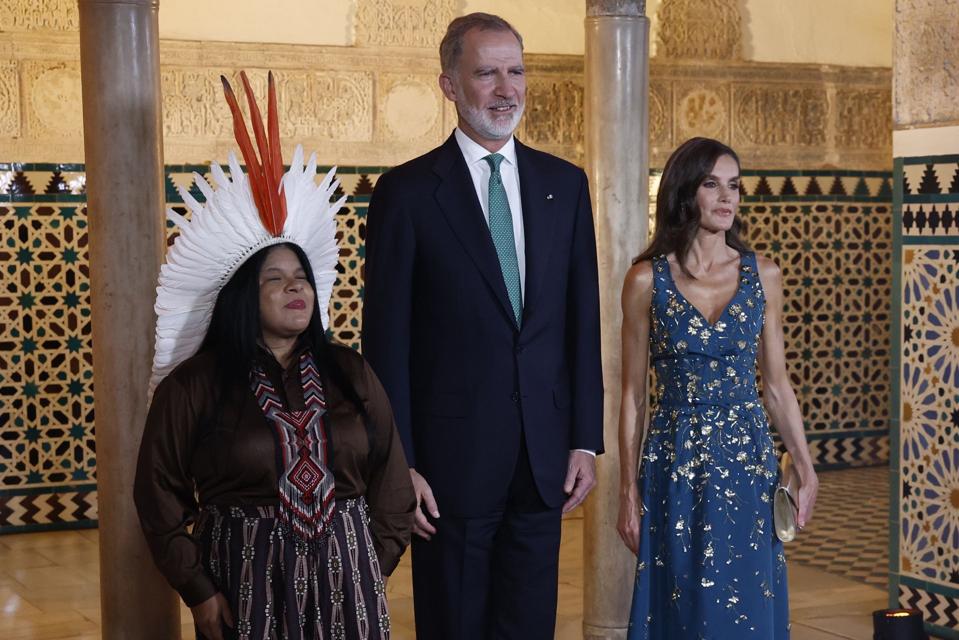 El rey Felipe VI (i) y la reina Letizia posan con una representante de pueblos indígenas