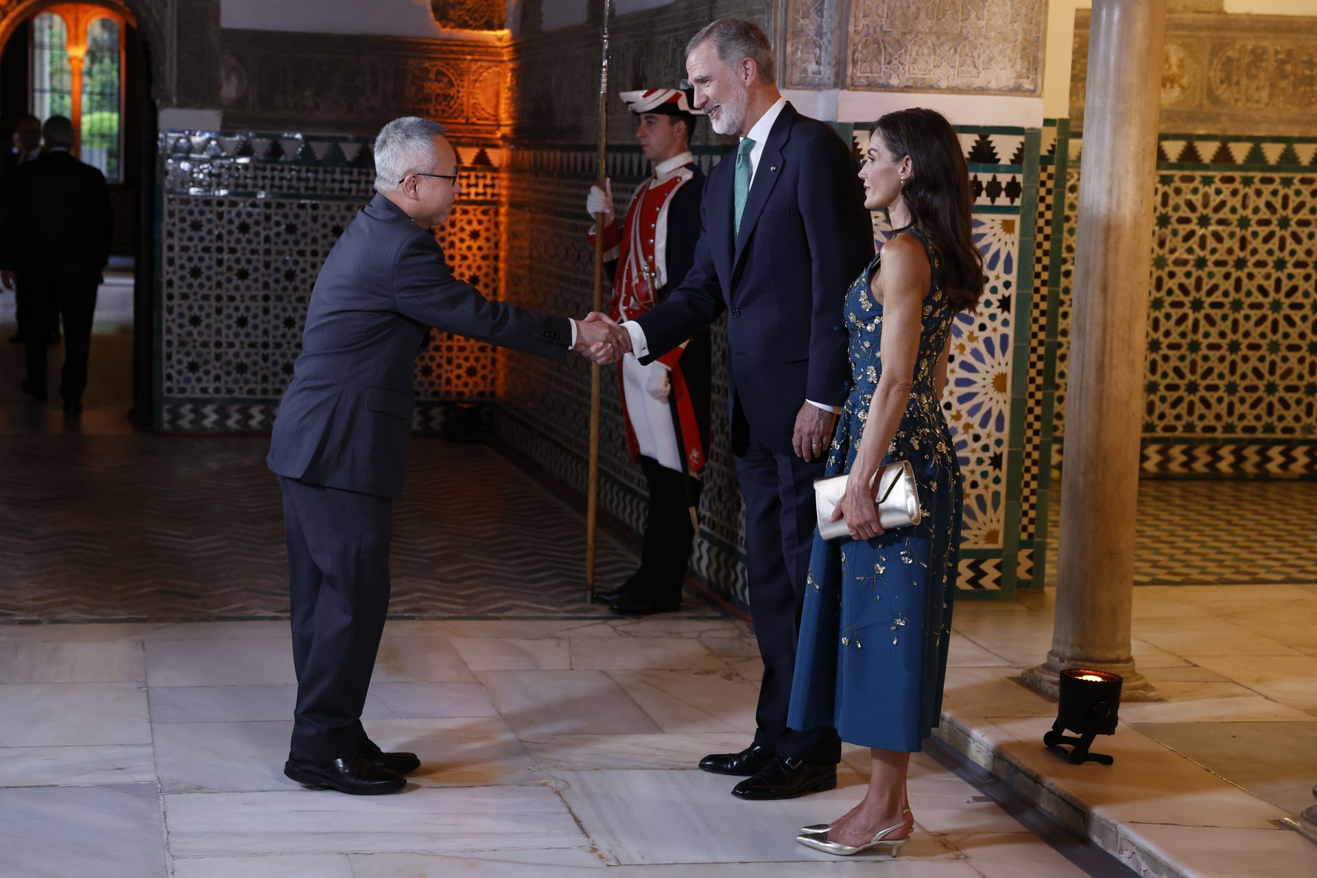 El rey Felipe VI (i) y la reina Letizia (d) saludan al Secretario General Adjunto de Asuntos Económicos y Sociales de las Naciones Unidas, Li Junhua (i)