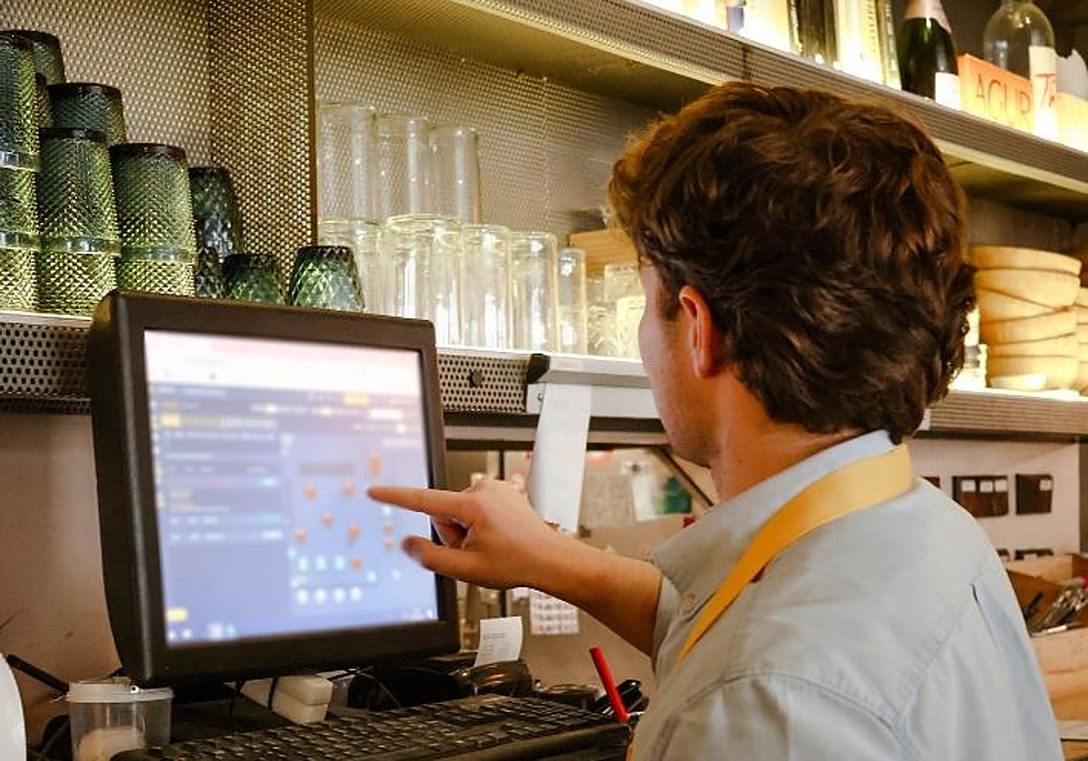 Un camarero gestiona las reservas de su establecimiento con tecnología de CoverManager