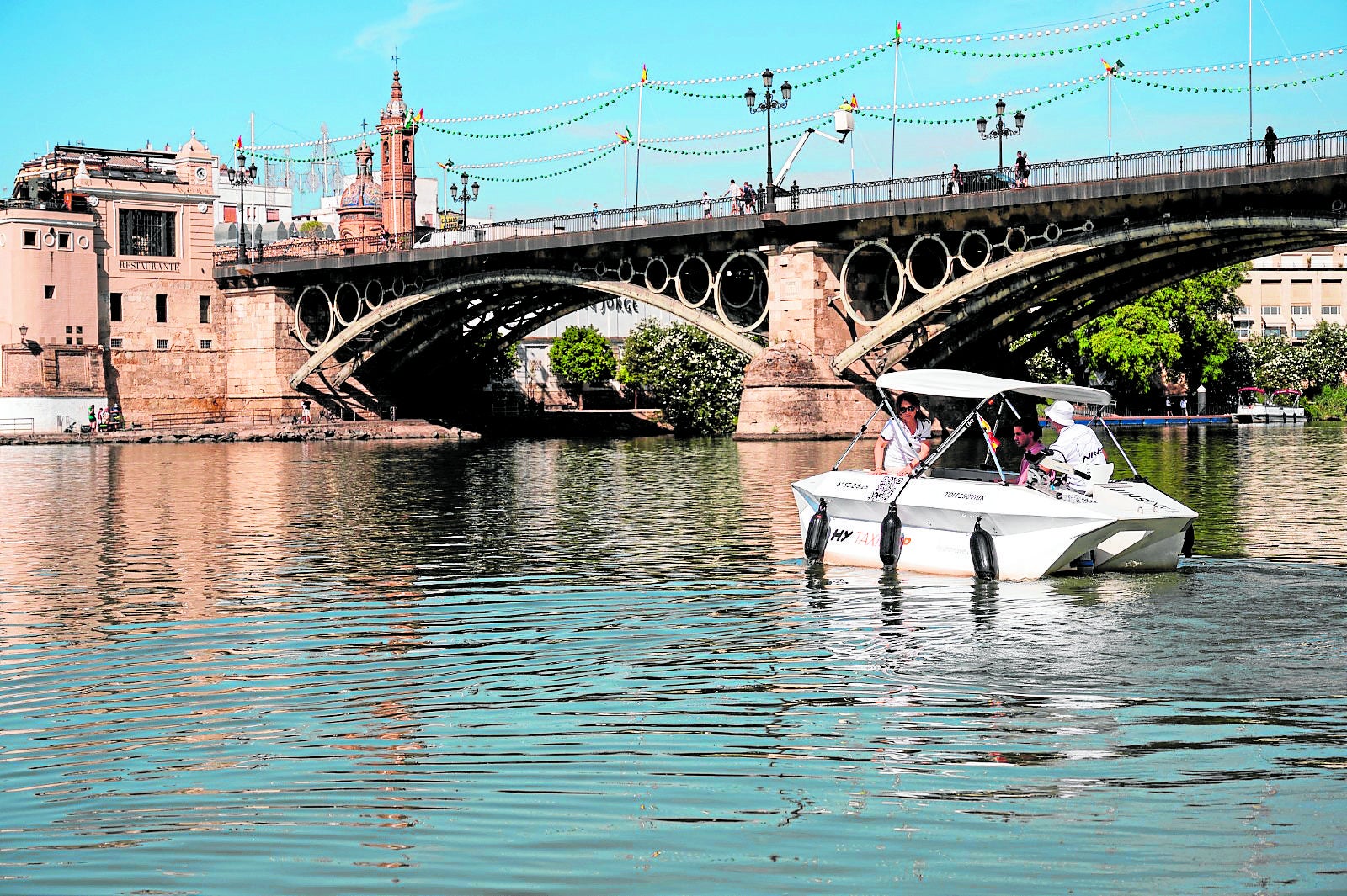 En la imagen la embarcación de 'Taxi Ship' junto al puente de Triana