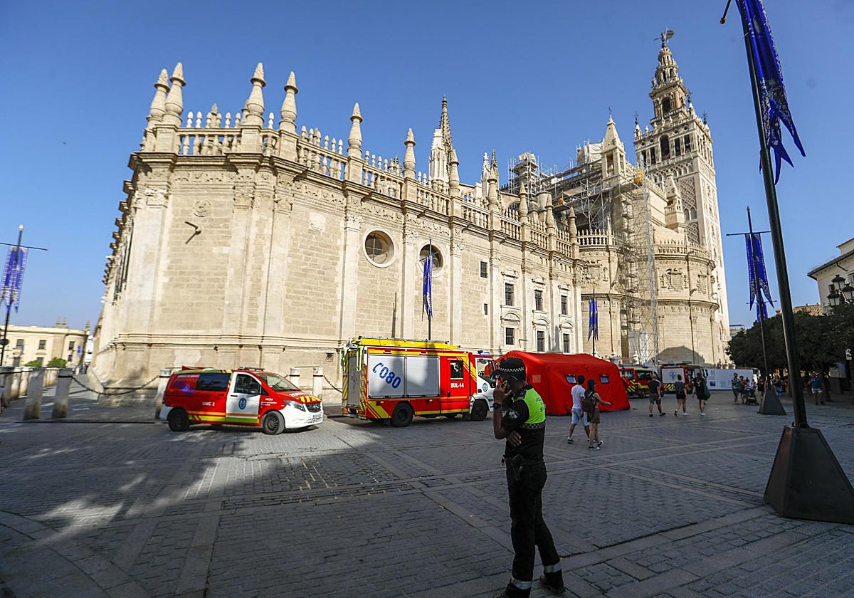 Un policía local atiende una llamada cerca de la Giralda en presencia de un amplio dispositivo de bomberos por el simulacro de 2024