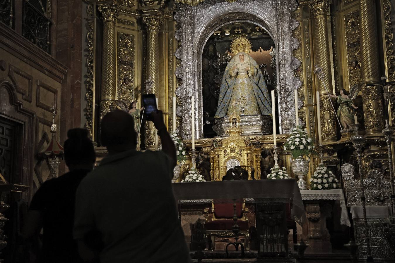 Hermanos y fieles pasan por el camarín de la Macarena antes de ser retirada al culto para su restauración