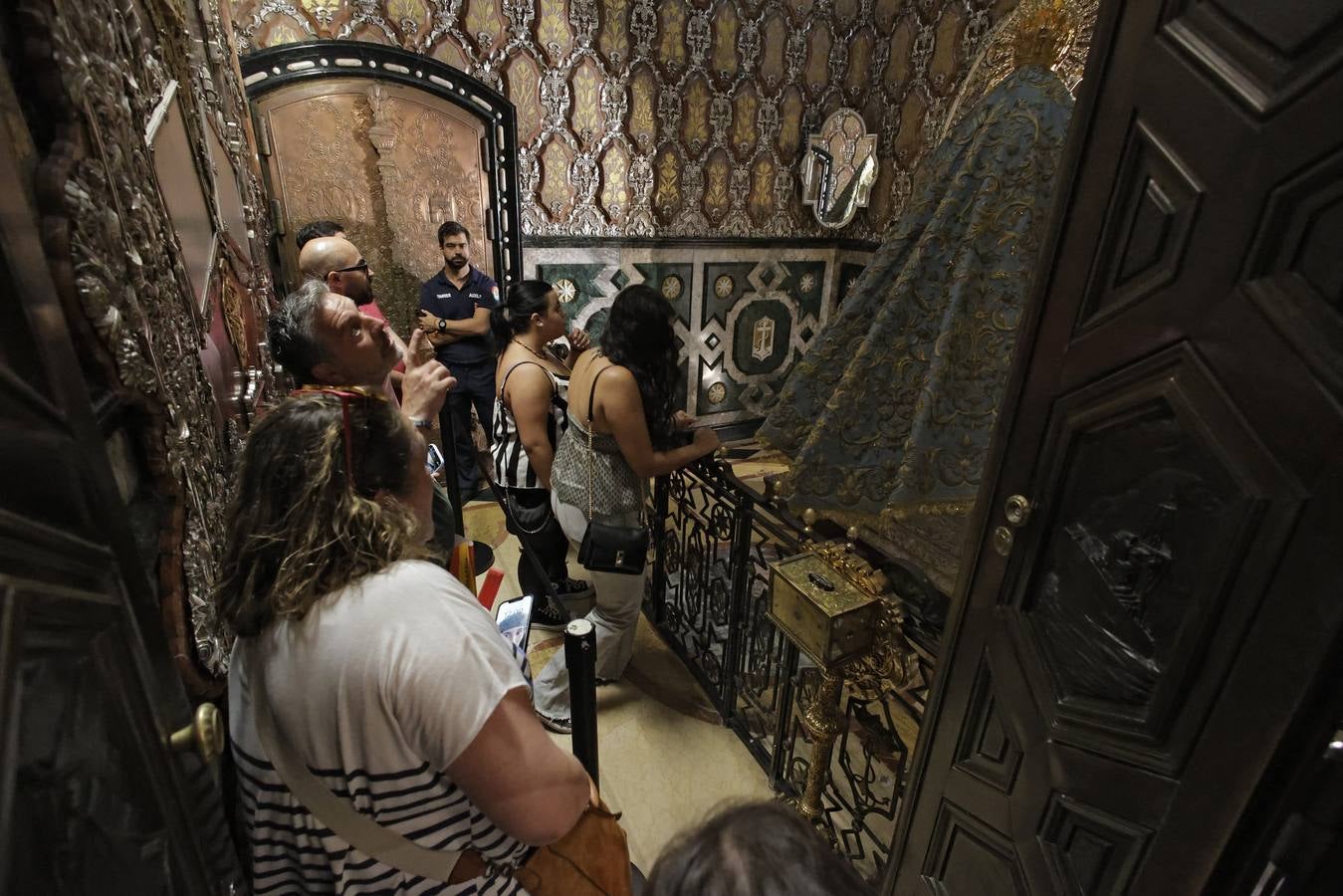 Hermanos y fieles pasan por el camarín de la Macarena antes de ser retirada al culto para su restauración