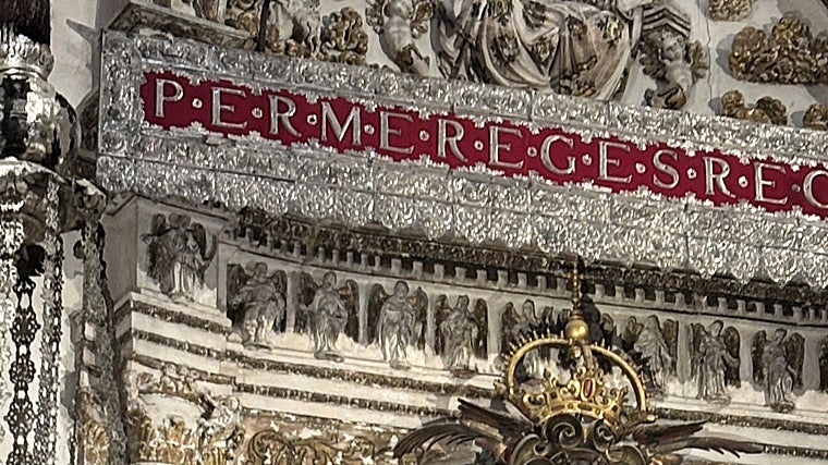 Lema en latín sobre el altar de la capilla Real de Sevilla: Per me reges regnat -«Por mi reinan los reyes»-, inspirado en el Libro de los Proverbios (8,15) y símbolo eterno de la unión entre la Virgen de los Reyes y la monarquía castellana e hisánica